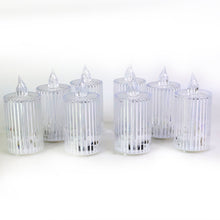Eight clear ribbed LED flameless candles unlit, arranged on a plain white background.