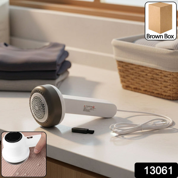 White and dark grey fabric lint remover with a USB cable on a counter, with an inset showing it in use on a pink sweater.