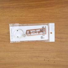 Lifestyle image of Radha Krishna metal keychain on a keyset