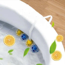 Four blue and yellow toilet cleaning balls hanging inside a white toilet bowl with lemon slices and leaves.