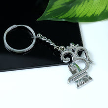 Side view of metal Om Shivling keychain with chain attached
