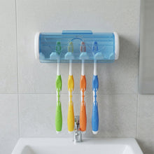 White and blue wall-mounted toothbrush holder with four colorful toothbrushes above a bathroom sink