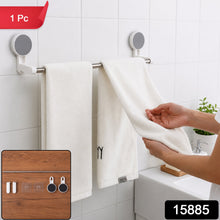 A person hangs a white towel on a silver self-adhesive towel rod in a white tiled bathroom, with a small inset image of