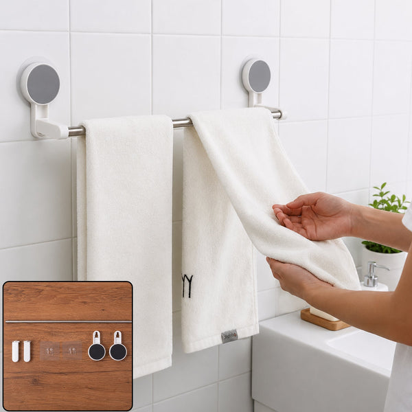 A person hangs a white towel on a silver self-adhesive towel rod in a white tiled bathroom.
