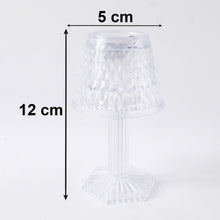 Small crystal table lamp creating a warm, ambient glow in a dark room.