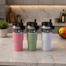 Three insulated tumblers in pink, green, and white with handles sit on a marble kitchen counter.