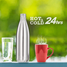 A silver stainless steel water bottle stands between a glass of water and a red steaming mug, with 