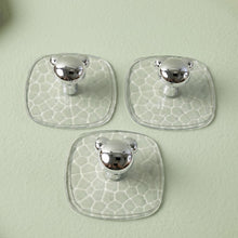 Clear adhesive wall hook holding a handbag in a hallway for convenient storage.