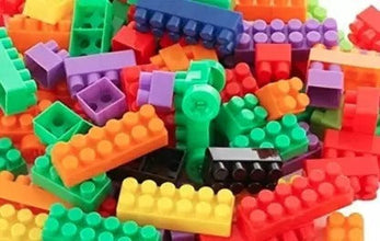Hand holding a few small building blocks, demonstrating the compatible design.