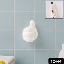 Close-up view of white palm-shaped multifunctional cable clip on wall