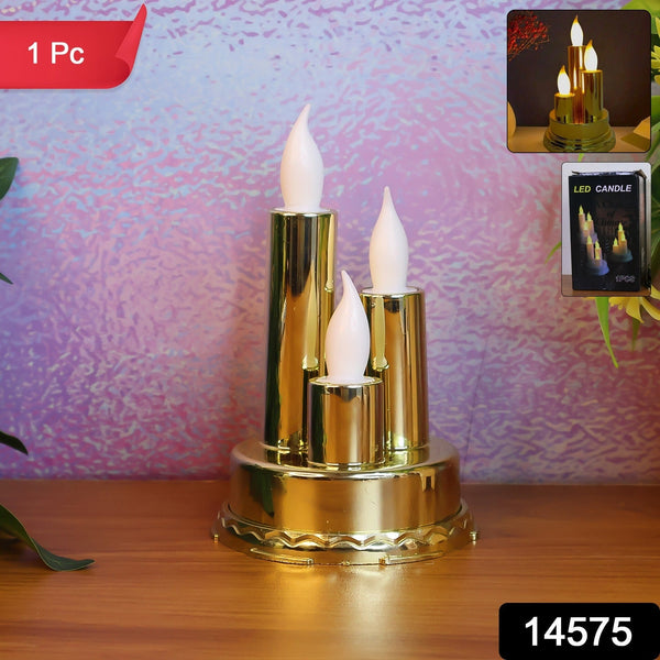 A golden triple LED flameless candle lamp stands on a wooden surface against a textured purple background.
