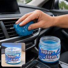 A hand presses blue cleaning gel into a car's air vent, with a jar of 