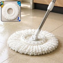 White microfiber mop head attached to a silver handle, resting on a tiled floor with cleaning supplies in the background.