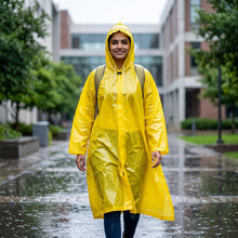 Long yellow rain poncho in use, demonstrating its free-size fit and coverage.