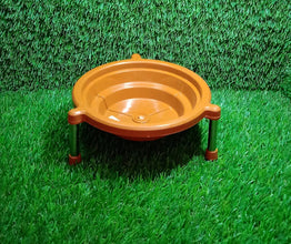 Orange plastic stand with three silver legs on a vibrant green artificial grass background.