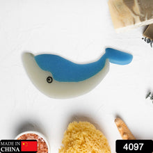 The blue and white dolphin sponge is centered on a white surface with bath items, including a 