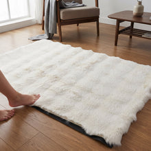 A person's bare feet stepping onto a cream fluffy faux fur rug on a wooden floor in a living room.