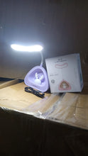 Compact LED desk light with button control on a clean workspace.