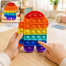 A child's hands press the bubbles of a rainbow Among Us character pop-it fidget toy on a wooden table.