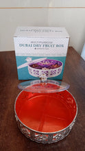 Round silver dry fruit box displayed for home serving on a table.