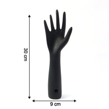 Black hand jewelry display stand placed on shelf for accessories