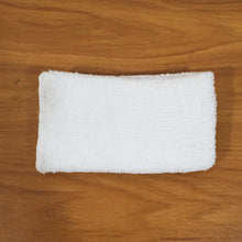 Person cleaning wooden furniture surface with microfiber cloth