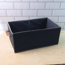 Foldable rectangular organizer bin shown neatly holding household items