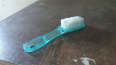 Plastic scrubbing brush featuring an ergonomic handle design.