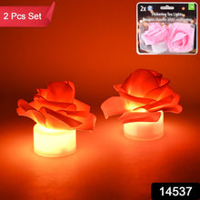 Two glowing orange LED rose tea lights with a product label for 