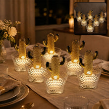 Six gold cactus LED lights in clear textured pots illuminate a dining table at night.