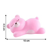 Portable sleeping bear night light held in hand demonstrating its compact size.