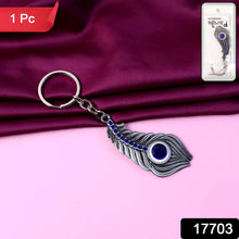 Close view of crystal adorned peacock feather keychain in metal