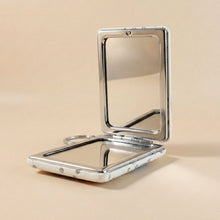 Foldable compact mirror keychain demonstrating dual-sided mirrors