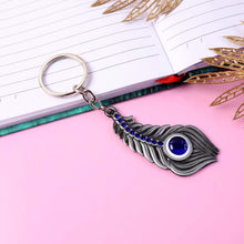 Silver-toned metal peacock feather keychain displayed on white background