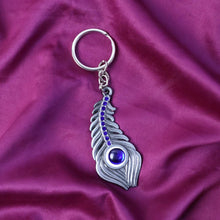 Stylish metal keychain with peacock feather motif and blue gem