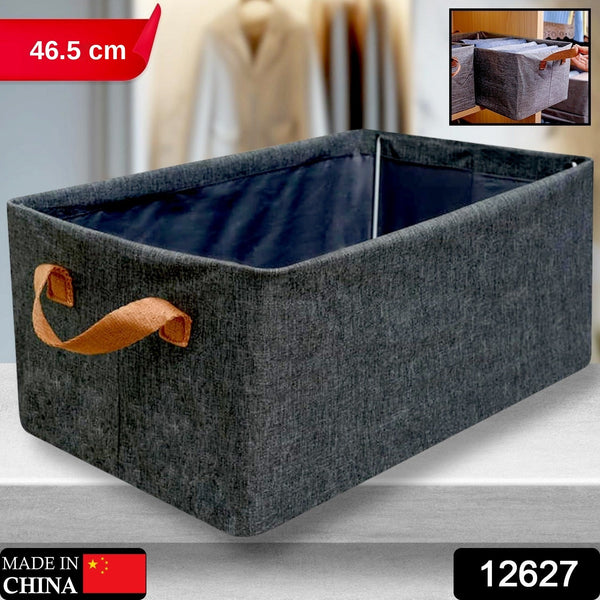 A single grey fabric storage box with brown handles on a grey surface, with a small inset image.