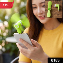 A woman holds a phone with a bright green USB-C fan plugged in, with a 