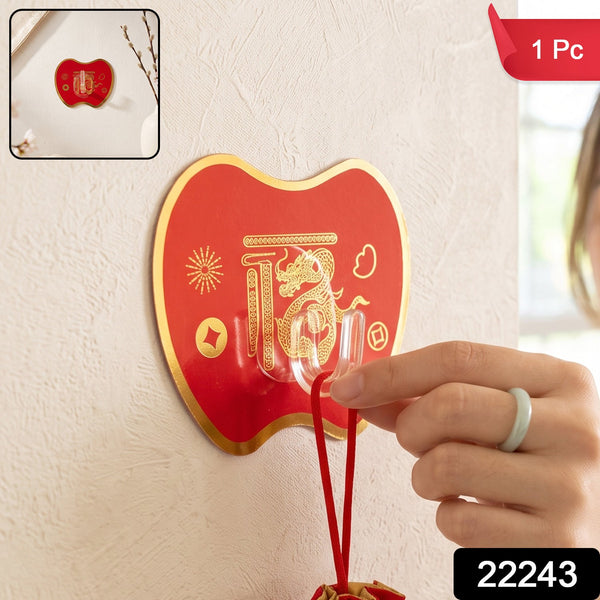 A hand hangs a red drawstring pouch on a red apple-shaped hook with gold Chinese characters and a dragon design. – view 2