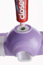 White automatic toothpaste dispenser and 4-slot toothbrush holder mounted on a wall.