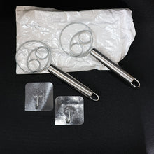 Two stainless steel spiral hand whisks placed on kitchen countertop